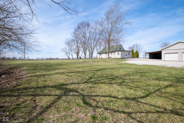 view of yard with an outdoor structure, a garage, and driveway