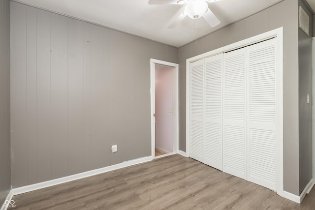 unfurnished bedroom with a ceiling fan, light wood-type flooring, a closet, and baseboards