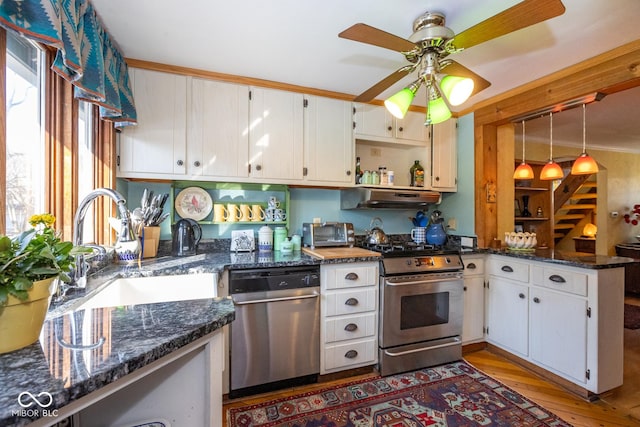 kitchen with under cabinet range hood, appliances with stainless steel finishes, a peninsula, white cabinets, and a ceiling fan