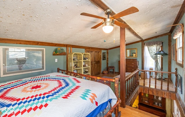 bedroom with lofted ceiling, a textured ceiling, and wood finished floors