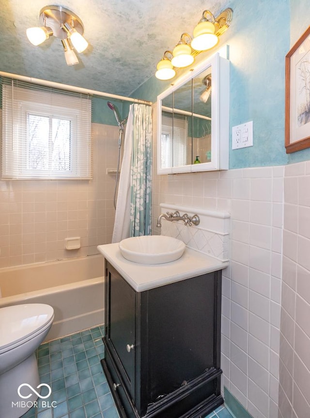 full bathroom with vanity, shower / bathtub combination with curtain, tile walls, toilet, and tile patterned floors