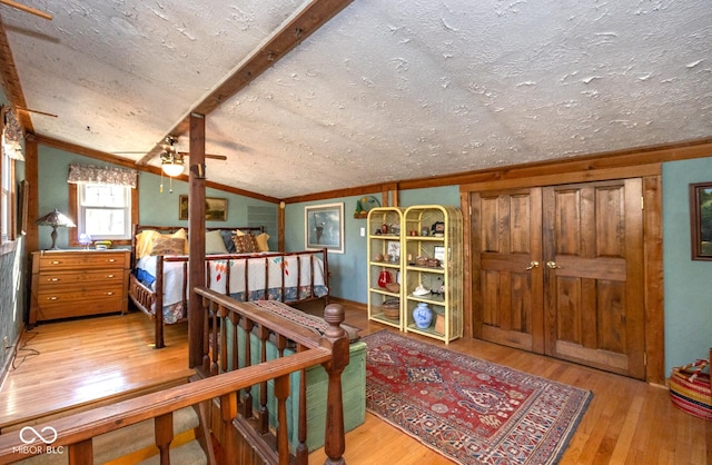 interior space featuring lofted ceiling, a textured ceiling, and wood-type flooring