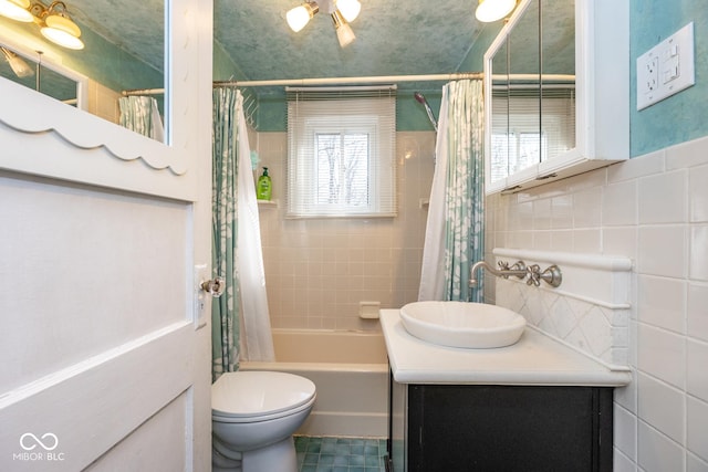 full bathroom with vanity, tile walls, toilet, and shower / bath combo