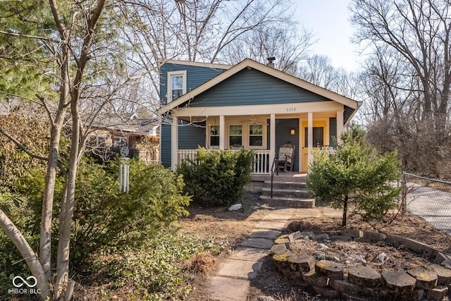 bungalow-style house with a porch and fence