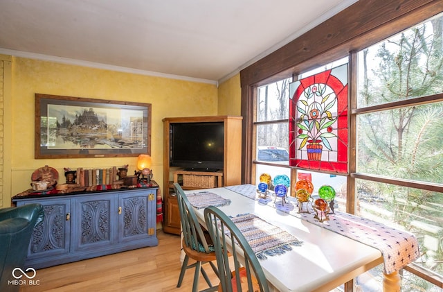 dining space with light wood-style flooring and ornamental molding