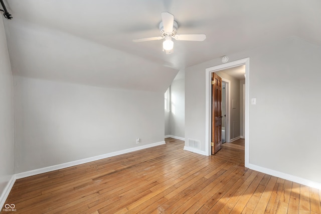 bonus room featuring visible vents, light wood finished floors, baseboards, ceiling fan, and vaulted ceiling