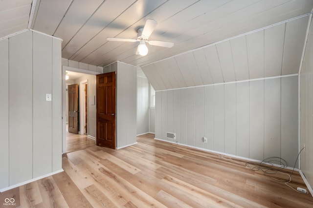 additional living space featuring lofted ceiling, light wood-style flooring, a ceiling fan, and visible vents