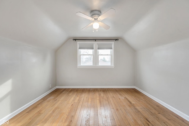 additional living space featuring lofted ceiling, light wood-type flooring, baseboards, and ceiling fan