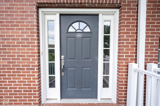 property entrance featuring brick siding