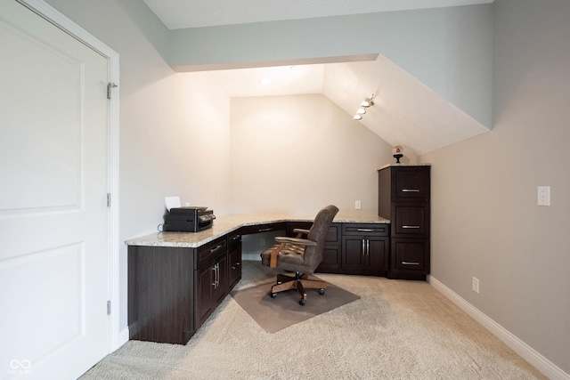 office featuring baseboards, light colored carpet, built in study area, and lofted ceiling