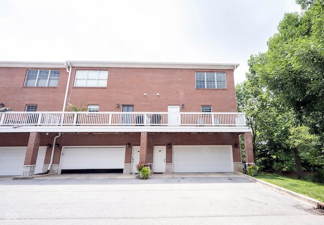 view of front of property featuring driveway, brick siding, and an attached garage