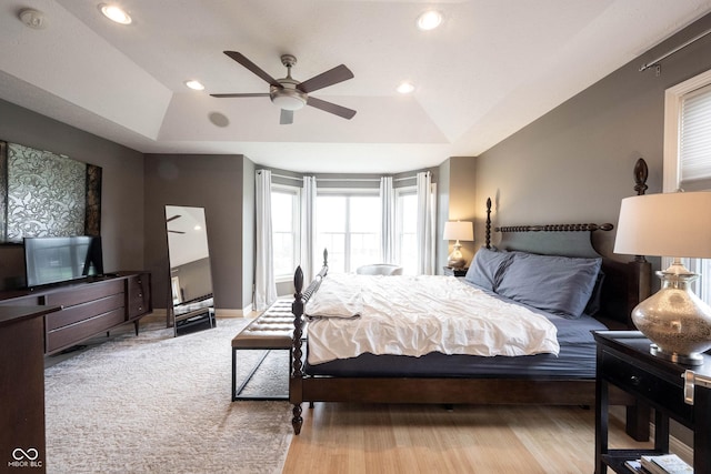 bedroom featuring recessed lighting, a tray ceiling, baseboards, and a ceiling fan