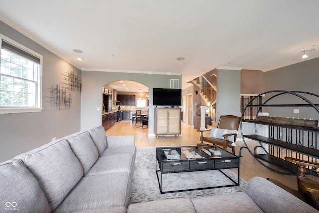 living area with visible vents, stairs, ornamental molding, wood finished floors, and arched walkways