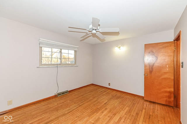 empty room featuring visible vents, baseboards, light wood-style floors, and ceiling fan