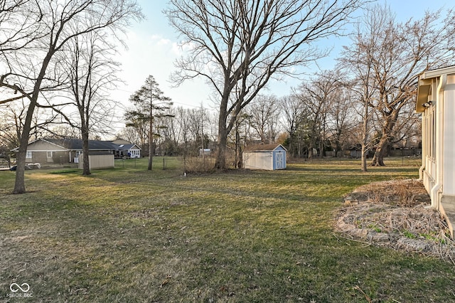 view of yard featuring an outbuilding, a storage unit, and fence