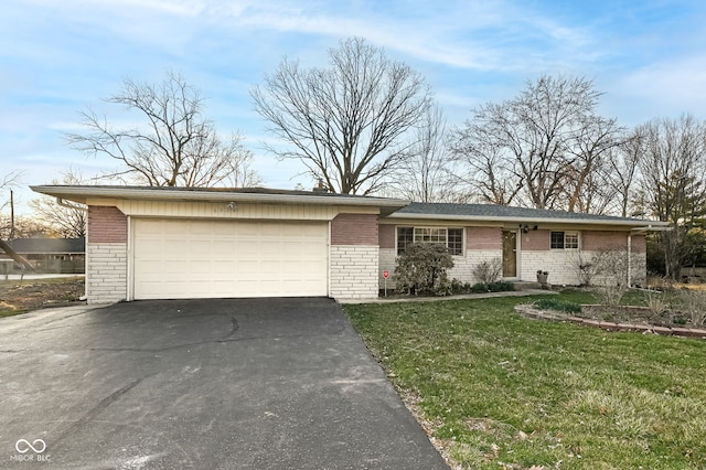 ranch-style house featuring aphalt driveway, an attached garage, a front lawn, and brick siding