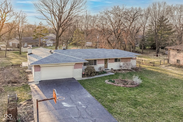 single story home with brick siding, an attached garage, concrete driveway, and a front yard