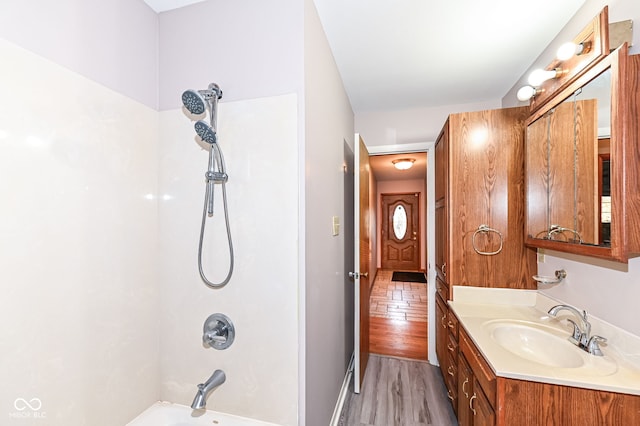 bathroom with wood finished floors, bathtub / shower combination, and vanity