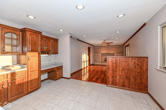 kitchen featuring built in study area, recessed lighting, ceiling fan, light countertops, and brown cabinets