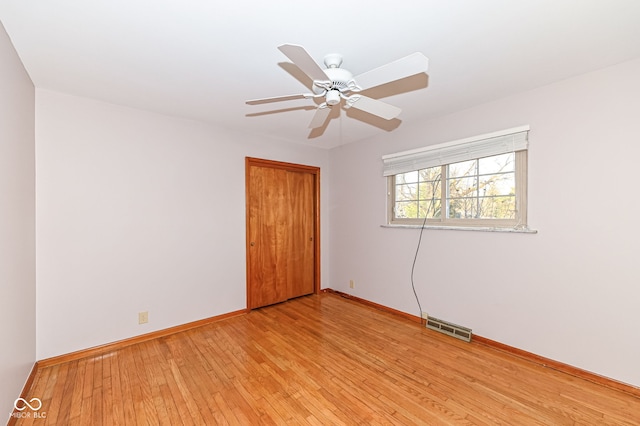 unfurnished bedroom featuring light wood-style floors, visible vents, a closet, and baseboards