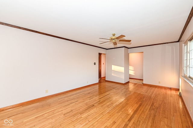 unfurnished room featuring crown molding, light wood-style flooring, a ceiling fan, and baseboards