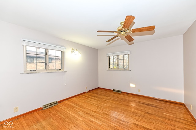 empty room featuring visible vents, baseboards, a ceiling fan, and light wood finished floors