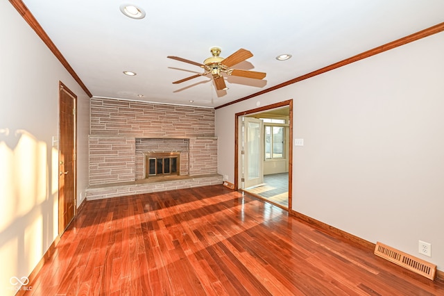 unfurnished living room with visible vents, wood finished floors, a fireplace, and crown molding