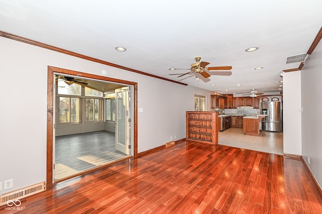 unfurnished living room featuring wood finished floors, visible vents, recessed lighting, ceiling fan, and crown molding