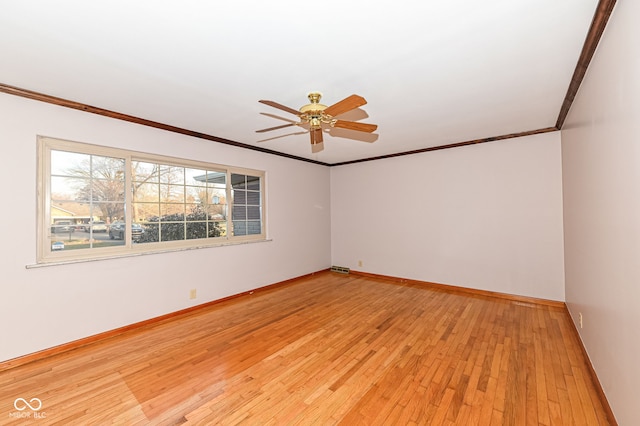 spare room with ceiling fan, baseboards, light wood finished floors, and ornamental molding