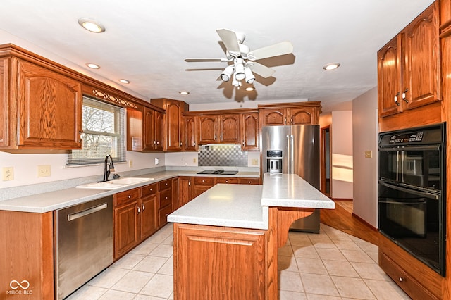 kitchen with light tile patterned flooring, black appliances, light countertops, and a sink