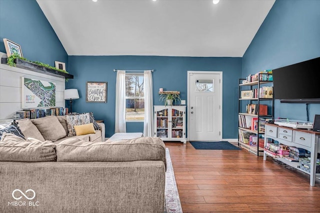 living area with wood finished floors and vaulted ceiling