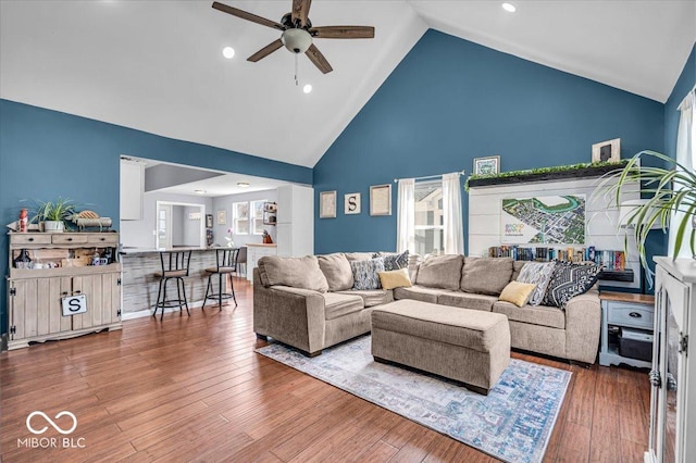 living room with high vaulted ceiling, a ceiling fan, and hardwood / wood-style flooring