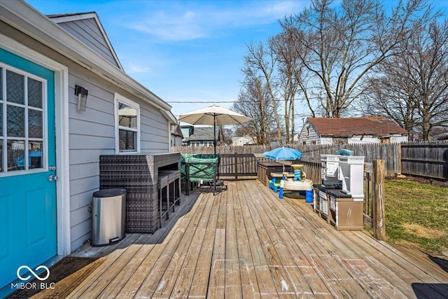 wooden terrace with a fenced backyard