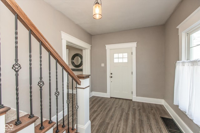 entryway with visible vents, baseboards, dark wood-style floors, and stairs