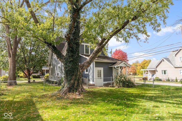 view of home's exterior featuring a lawn and fence