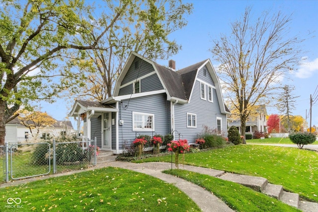 view of front facade featuring a gate, fence, a gambrel roof, a shingled roof, and a front lawn