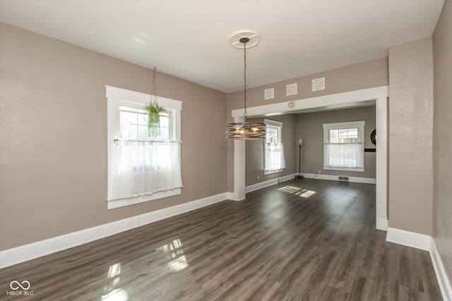 unfurnished dining area featuring visible vents, dark wood-style floors, and baseboards