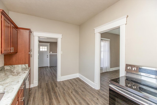 kitchen featuring brown cabinetry, electric range, baseboards, and dark wood-style flooring