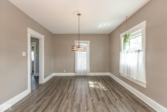 spare room with dark wood-type flooring and baseboards