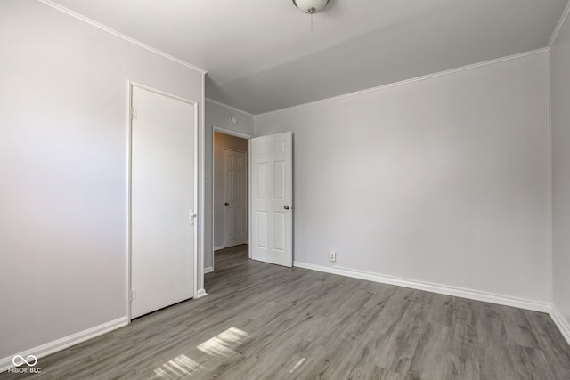 unfurnished bedroom with crown molding, baseboards, and wood finished floors