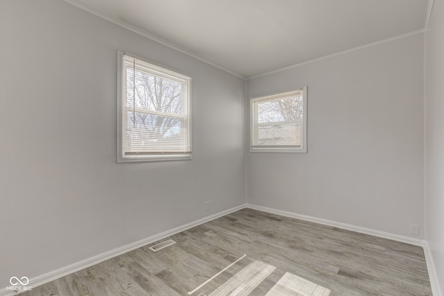 unfurnished room with baseboards, light wood-style floors, and crown molding