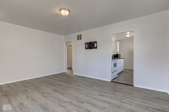 unfurnished living room with visible vents, light wood-style flooring, baseboards, and ornamental molding