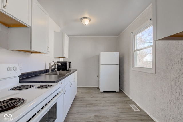 kitchen featuring white appliances, white cabinetry, light wood-type flooring, and a sink