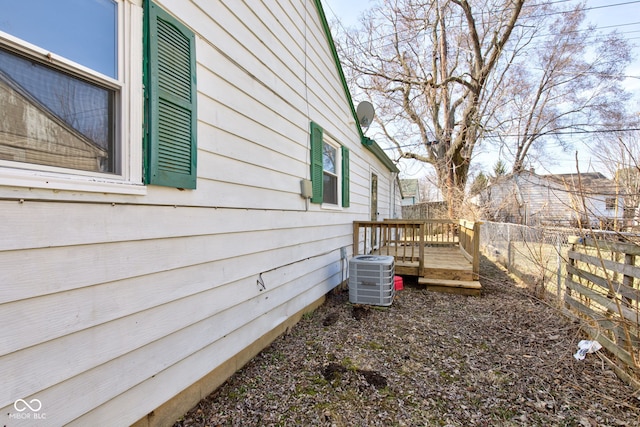 view of yard with fence, central AC, and a wooden deck