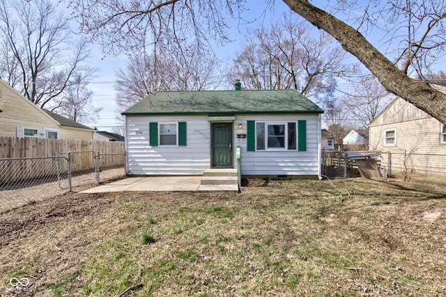 view of front of home featuring a front yard, a fenced backyard, and a shingled roof