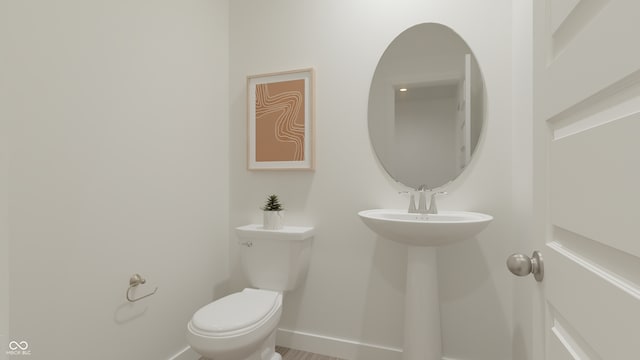 bathroom with toilet and baseboards