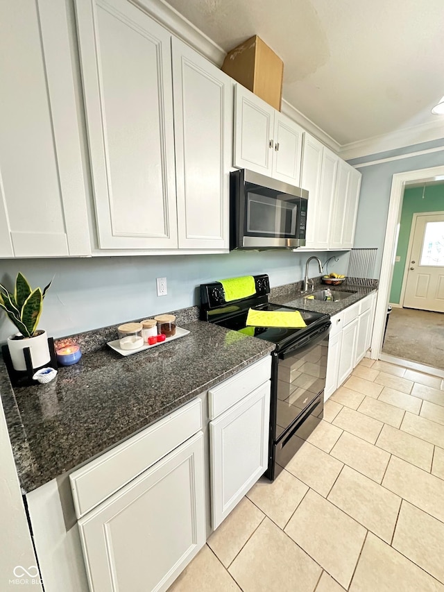 kitchen with white cabinetry, stainless steel microwave, black electric range, and crown molding