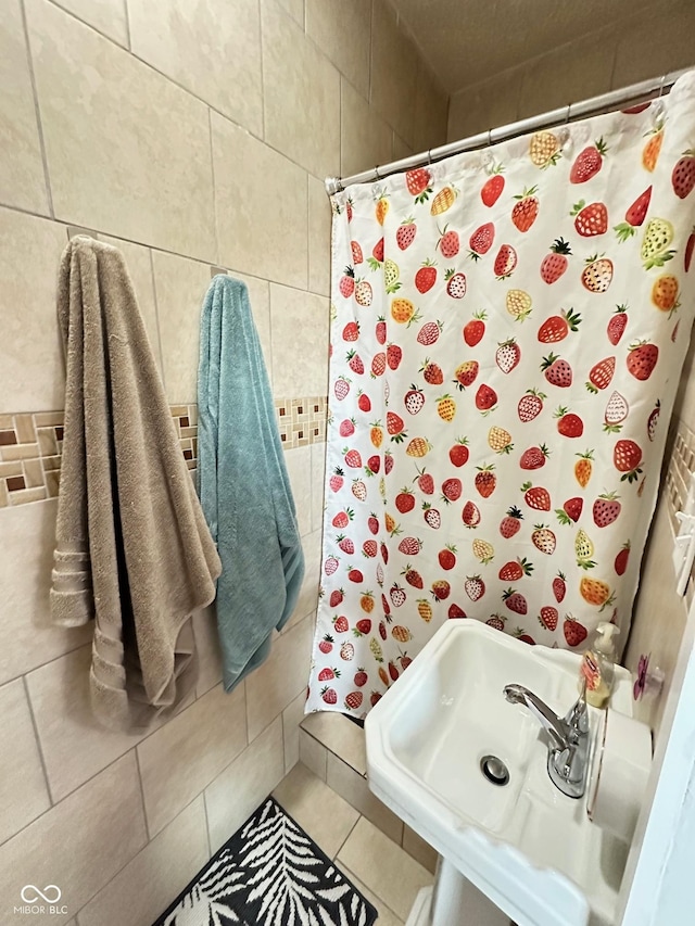 full bathroom with tile patterned floors, a shower with shower curtain, and a sink