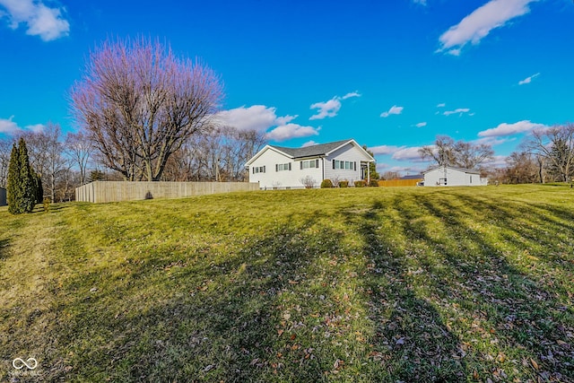 exterior space with fence and a lawn