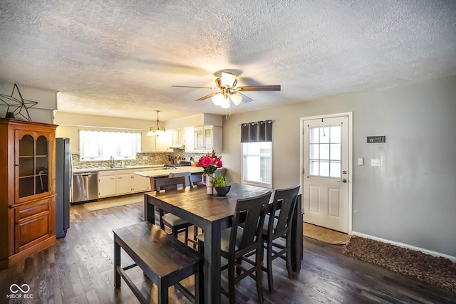 dining space with dark wood-style floors, plenty of natural light, and ceiling fan